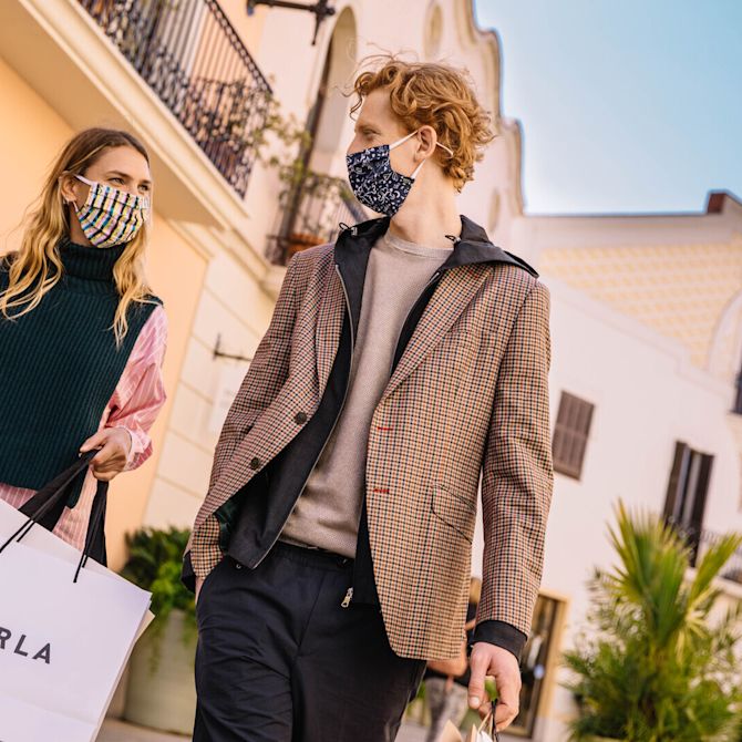 Couple with masks shopping at La Roca Village