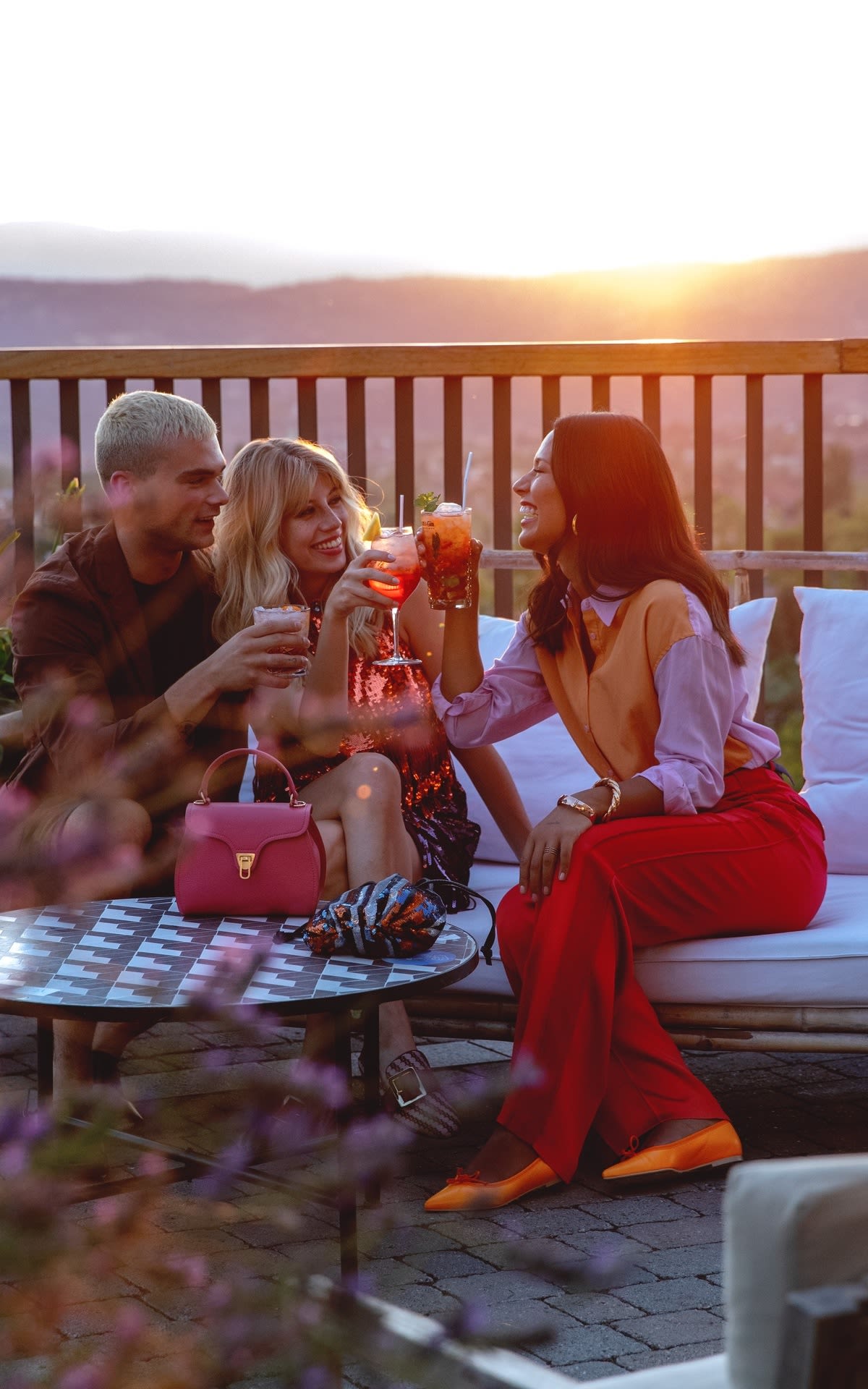 Foto amigos tomando una copa en la terraza con puesta de sol 