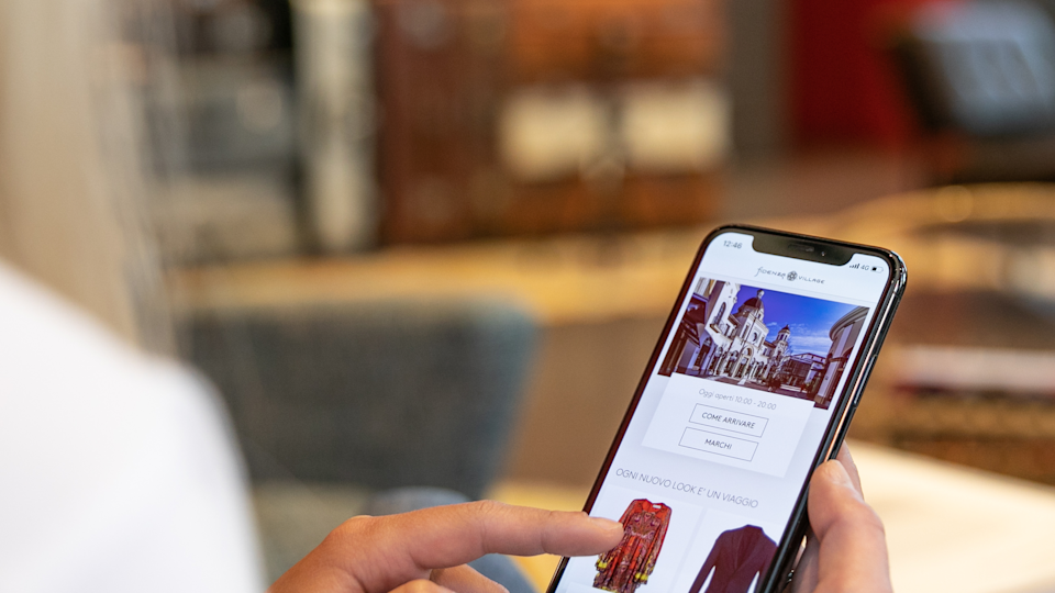 woman sitting on the sofa looking at the virtual mobile shopping