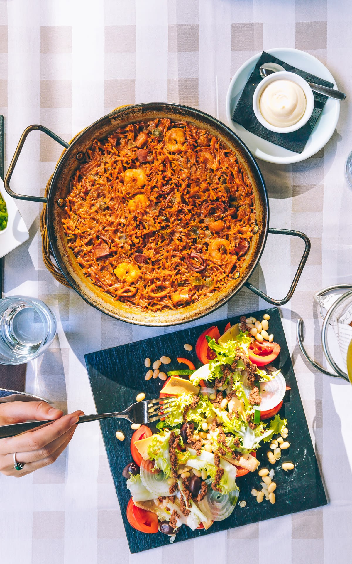 Table with paella and Mediterranean salad