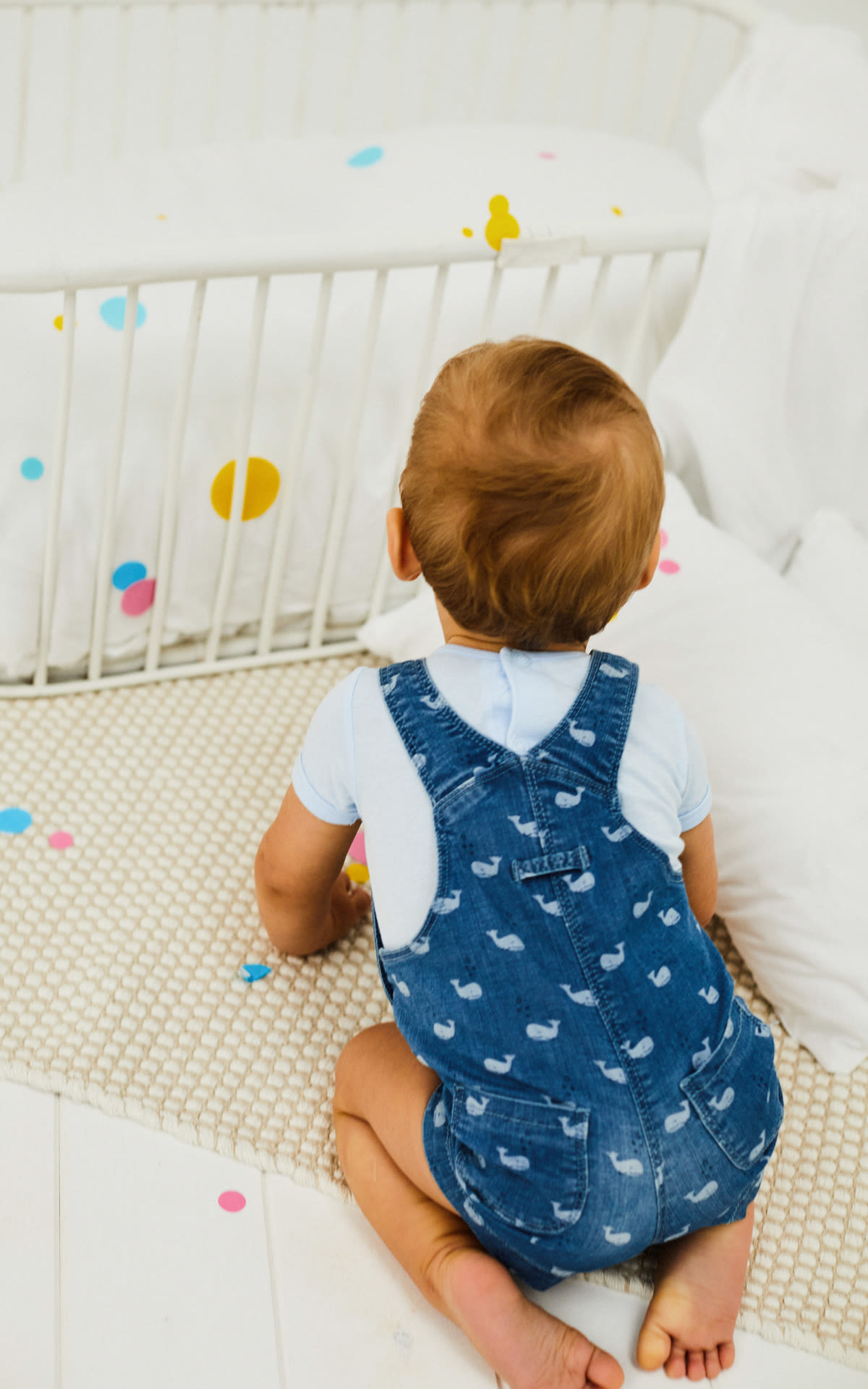 Baby in a crib with boboli clothes
