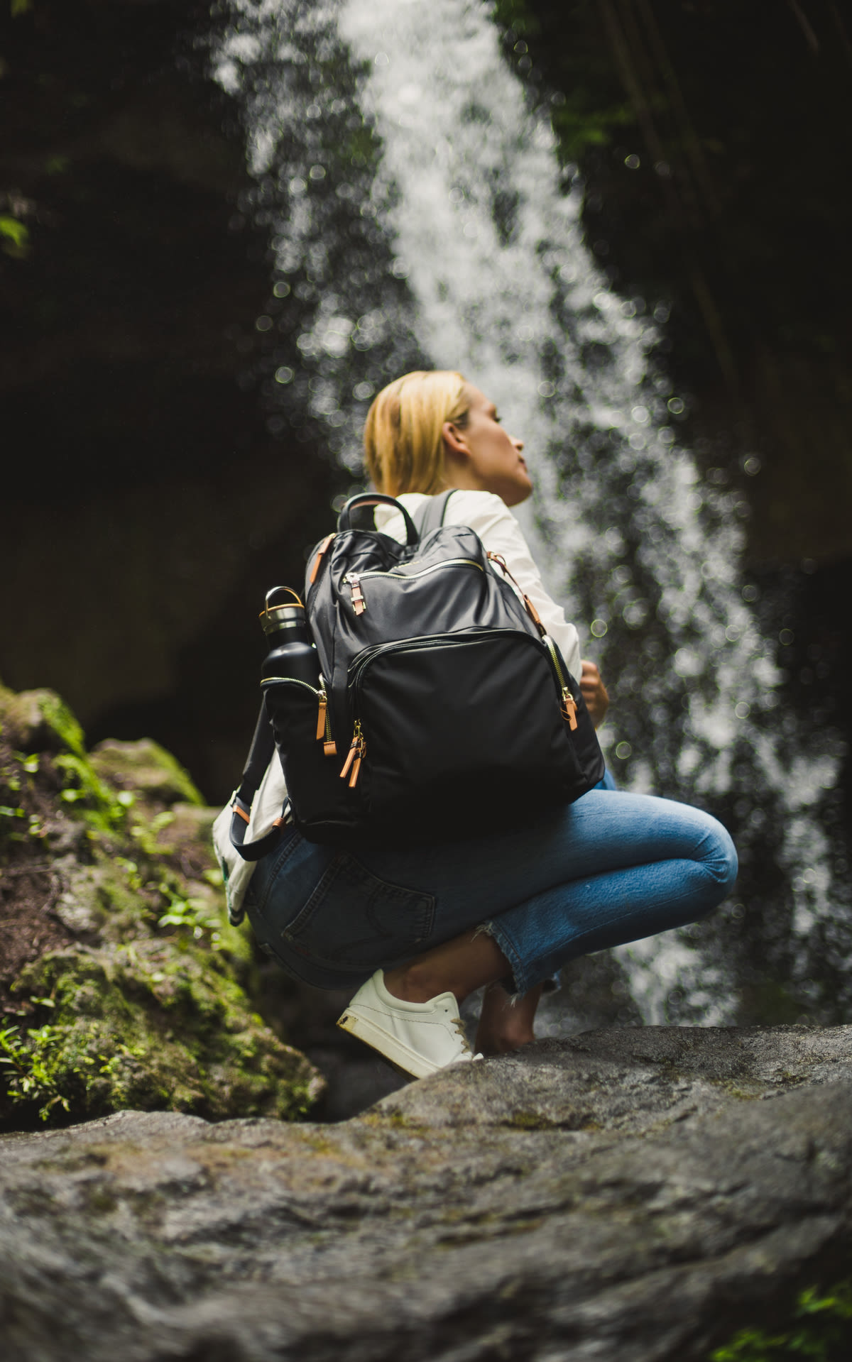 Chica en la montaña con una mochila con materiales reciclables de Tumi