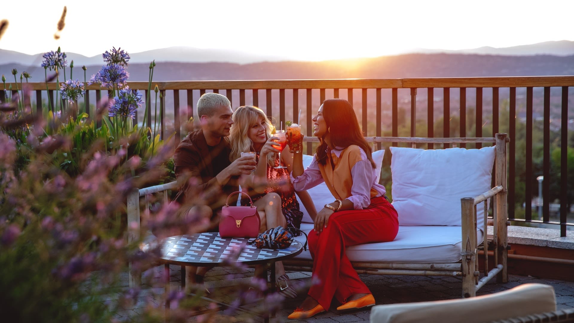 Foto amigos tomando una copa en la terraza con puesta de sol 